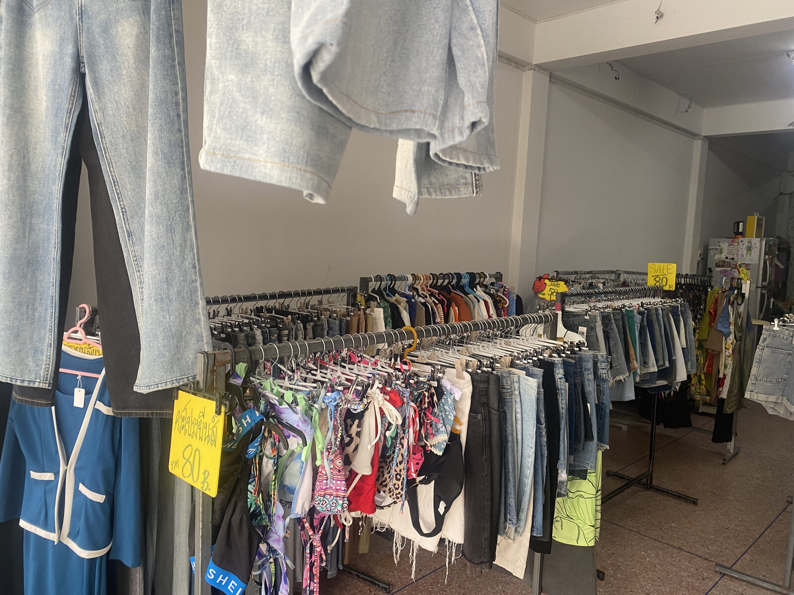 Racks of secondhand denim and swimwear inside Dokmai Vintage Denim in Nathon Town, Koh Samui